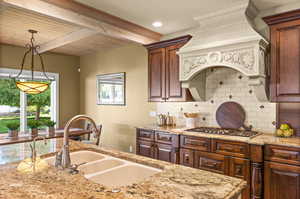 Kitchen with sink, a healthy amount of sunlight, decorative backsplash, and decorative light fixtures