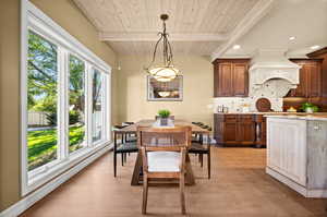 Dining area with wood ceiling, beam ceiling, and light hardwood / wood-style flooring