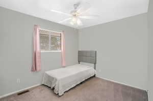 Carpeted bedroom featuring ceiling fan