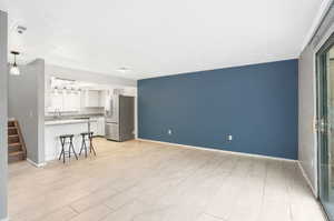 Unfurnished living room featuring sink and light tile patterned flooring