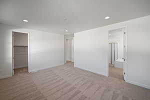 Spare room featuring light colored carpet and a textured ceiling