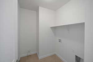 Washroom with light tile patterned flooring, gas dryer hookup, a textured ceiling, and hookup for a washing machine