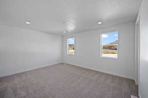 Carpeted empty room with a textured ceiling