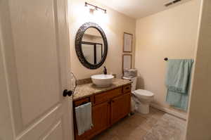 Bathroom with tile patterned flooring, vanity, and toilet