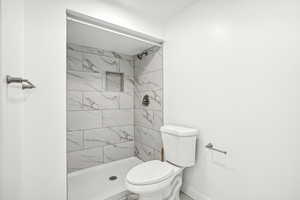 Bathroom with toilet and tiled shower