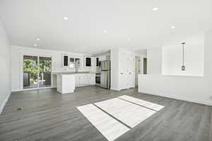 Unfurnished living room featuring sink and wood-type flooring