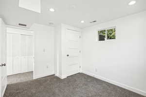 Unfurnished bedroom with dark carpet and a closet