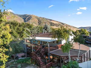 Aerial photo of back of house & decks near mountains.