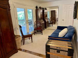 Carpeted owner's suite bedroom featuring french doors leading out to beautiful large deck, with a view.