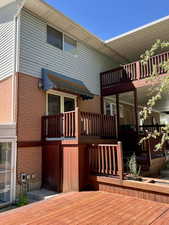 Back of property with a balcony and a deck