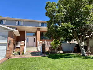 View of front of property featuring a front yard and covered porch