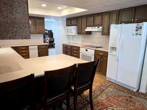 Kitchen featuring laminate flooring, white appliances