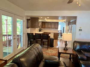 Kitchen connected to family room, featuring kitchen bar, and french doors,