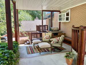 View of covered patio featuring a built in gas grill and wooden decks