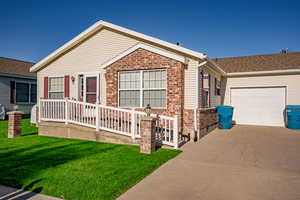 Ranch-style home featuring a front yard and a garage