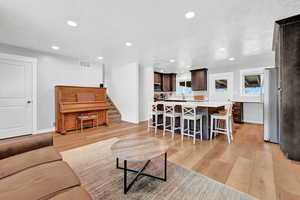 Living room with light hardwood / wood-style flooring and a textured ceiling