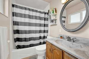 Full bathroom featuring shower / tub combo, toilet, and vanity