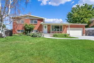 Split level home with a garage and a front yard