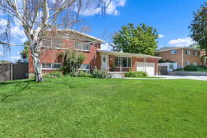 View of front of home with a garage and a front lawn