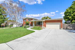 View of front of house featuring a front lawn and a garage