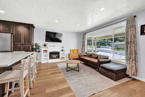 Living room featuring a textured ceiling and light wood-type flooring