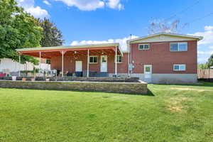 Back of property featuring ceiling fan and a lawn