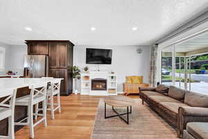 Living room with light hardwood / wood-style flooring and a textured ceiling