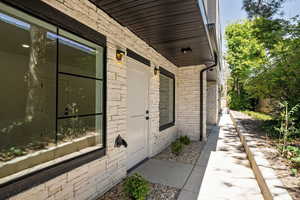 View of exterior entry with brick siding