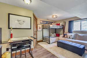 Interior space with a textured ceiling and light hardwood / wood-style floors