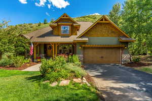 Craftsman-style house with a front lawn and a garage