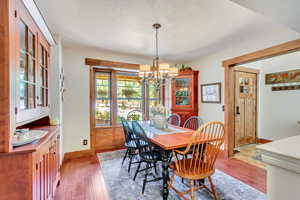 Dining room featuring wood-type flooring and a notable chandelier