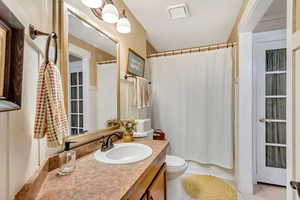 Bathroom featuring tile patterned flooring, toilet, and vanity