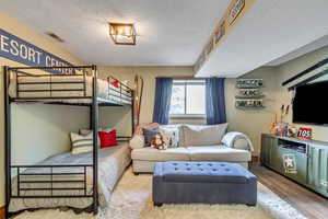 Bedroom featuring a textured ceiling and wood-type flooring