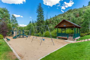 View of playground featuring a lawn and a gazebo