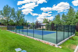 View of sport court with a lawn