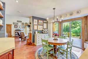 Dining area with light hardwood / wood-style floors and a notable chandelier