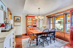 Dining space with light hardwood / wood-style floors and a chandelier