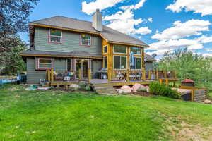 Rear view of property with a yard and a deck