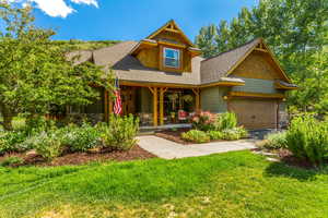 View of front of home featuring a garage, a porch, and a front yard