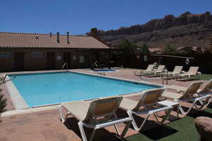 View of swimming pool with a patio and a mountain views of Moab Rim (also can see La Sal Mountains not pictured)