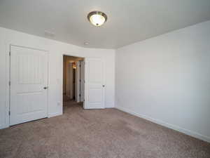 Unfurnished bedroom featuring light carpet