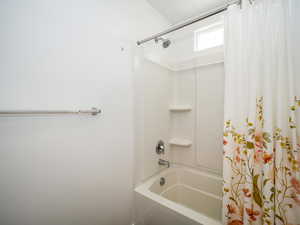 Bathroom with shower / bathtub combination with curtain