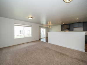 Unfurnished living room featuring an inviting chandelier and dark hardwood / wood-style flooring