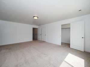 Unfurnished bedroom with a closet and light colored carpet