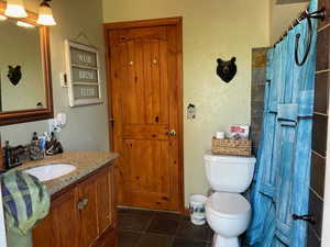 Bathroom featuring tile patterned flooring, toilet, and vanity