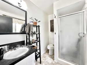 Bathroom featuring an enclosed shower, toilet, vanity, and tile patterned floors