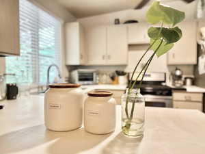 Kitchen with white cabinetry and range