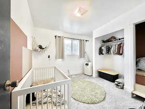 Bedroom featuring a closet, carpet, and a crib