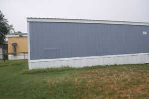 View of side of property with a lawn