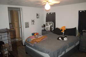 Bedroom featuring ceiling fan, a textured ceiling, and dark hardwood / wood-style floors